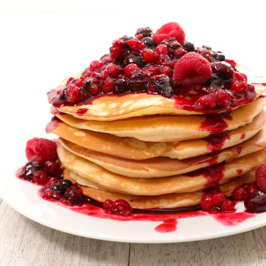 gluten free pancakes on a plate with mixed fruit